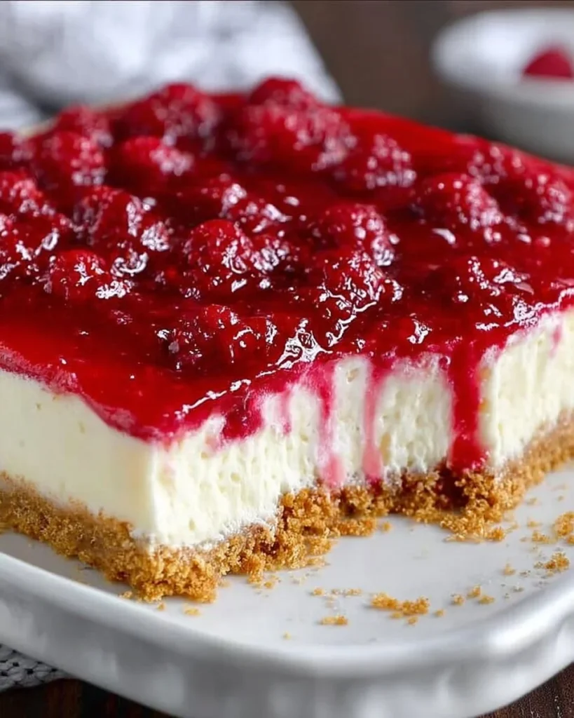 Dreamy raspberry cheesecake topped with fresh raspberries and a creamy layer