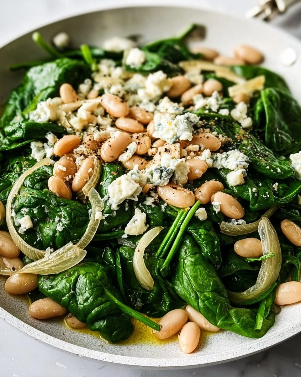 Sautéed spinach and white bean salad served in a bowl with vibrant colors