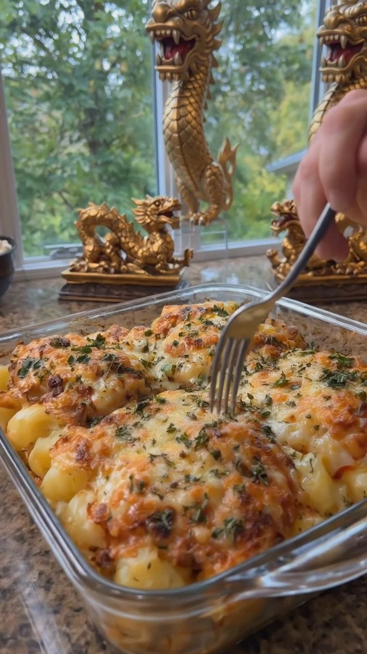 Cheesy baked chicken served with golden potatoes in a cozy kitchen setting.