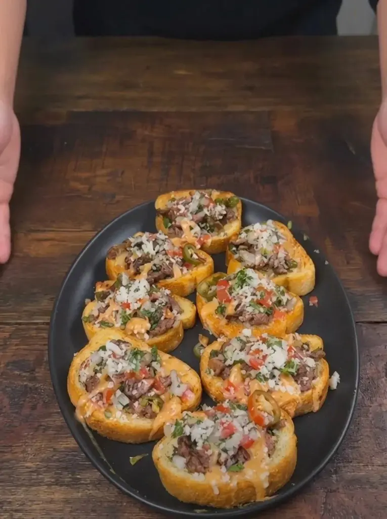 Grilled beef loaded Texas toast topped with cheese and fresh herbs.