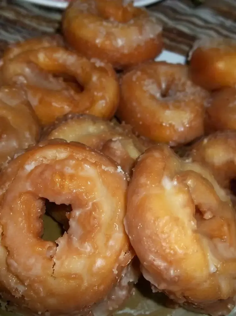 Old-Fashioned Sour Cream Donuts on a plate, freshly baked and dusted with powdered sugar.