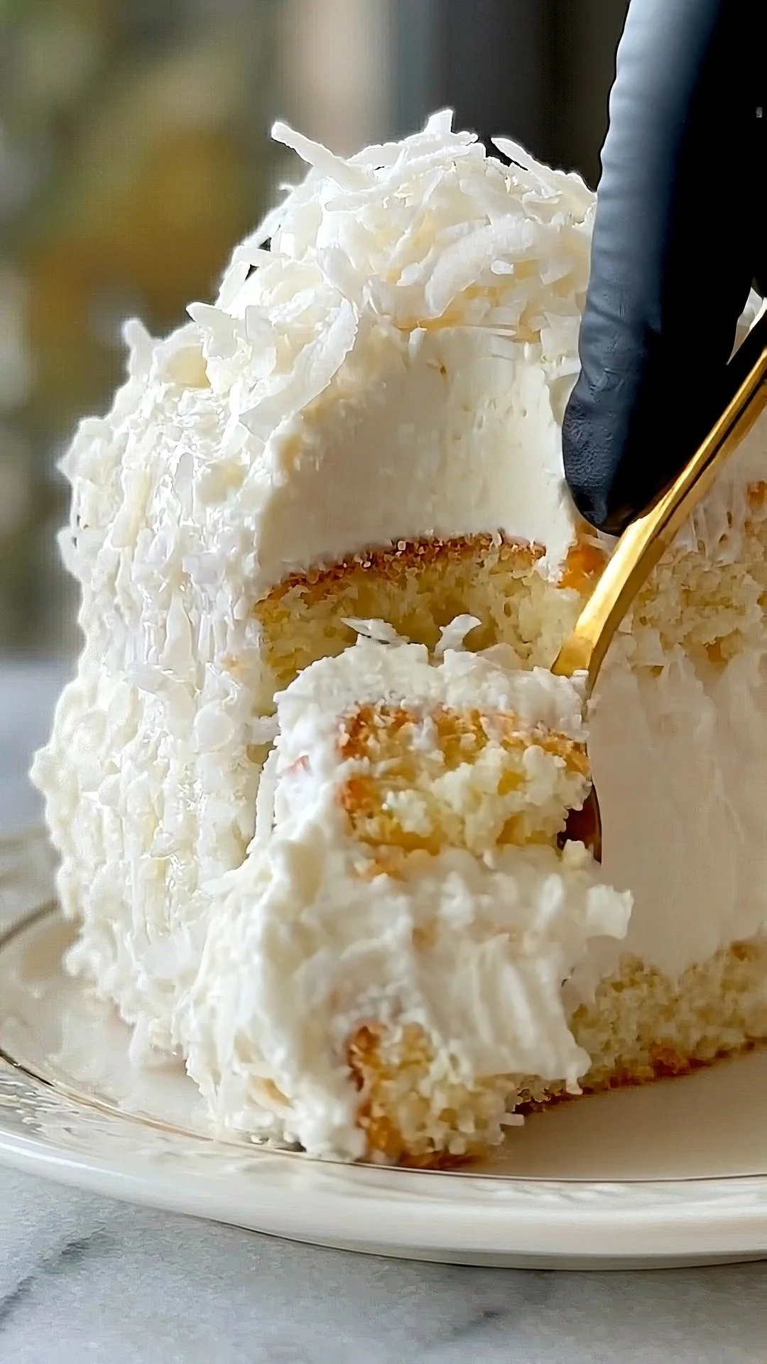 Slice of Coconut Cloud Cake topped with coconut flakes and whipped cream