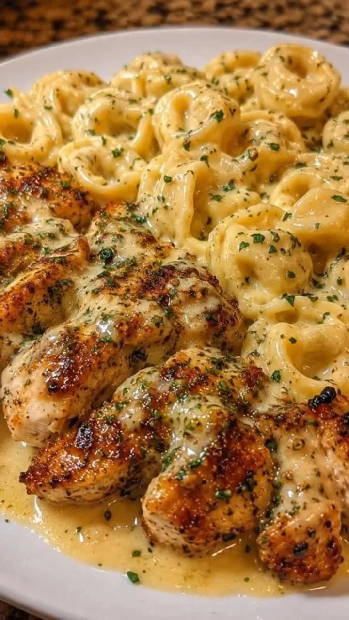 Bowl of creamy garlic parmesan tortellini topped with seared chicken