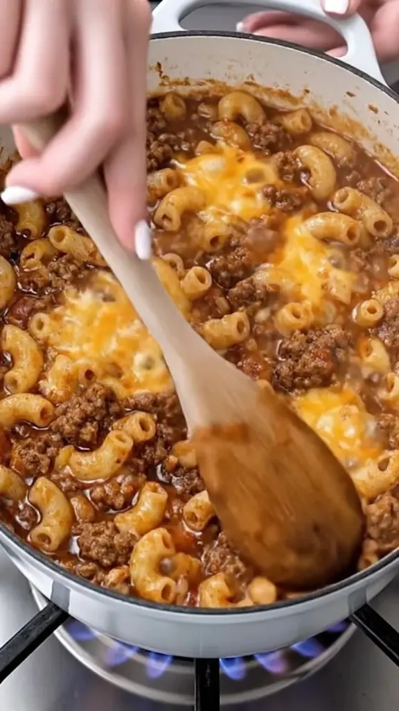Crockpot Cheesy Beef Macaroni served in a bowl topped with herbs