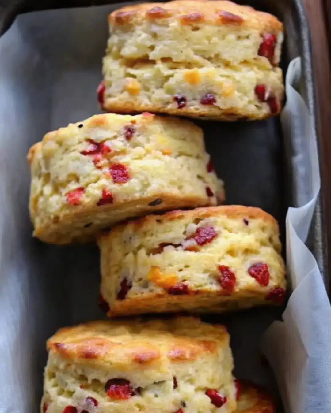 Freshly baked cranberry orange scones on a wooden table