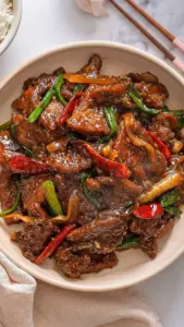 Delicious plate of Mongolian Beef with tender beef and colorful vegetables.