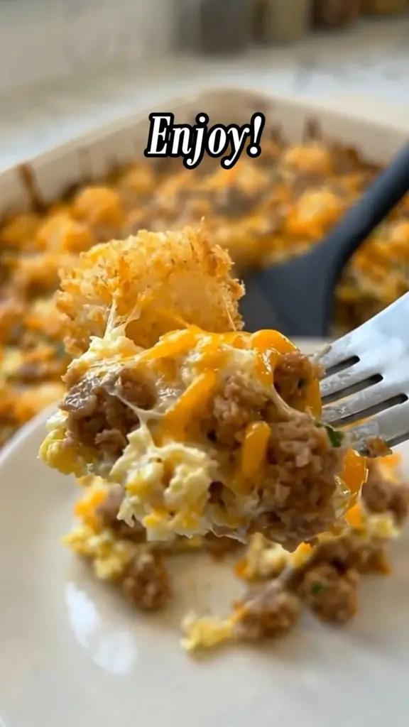 Sausage cream cheese tater tot breakfast casserole topped with herbs