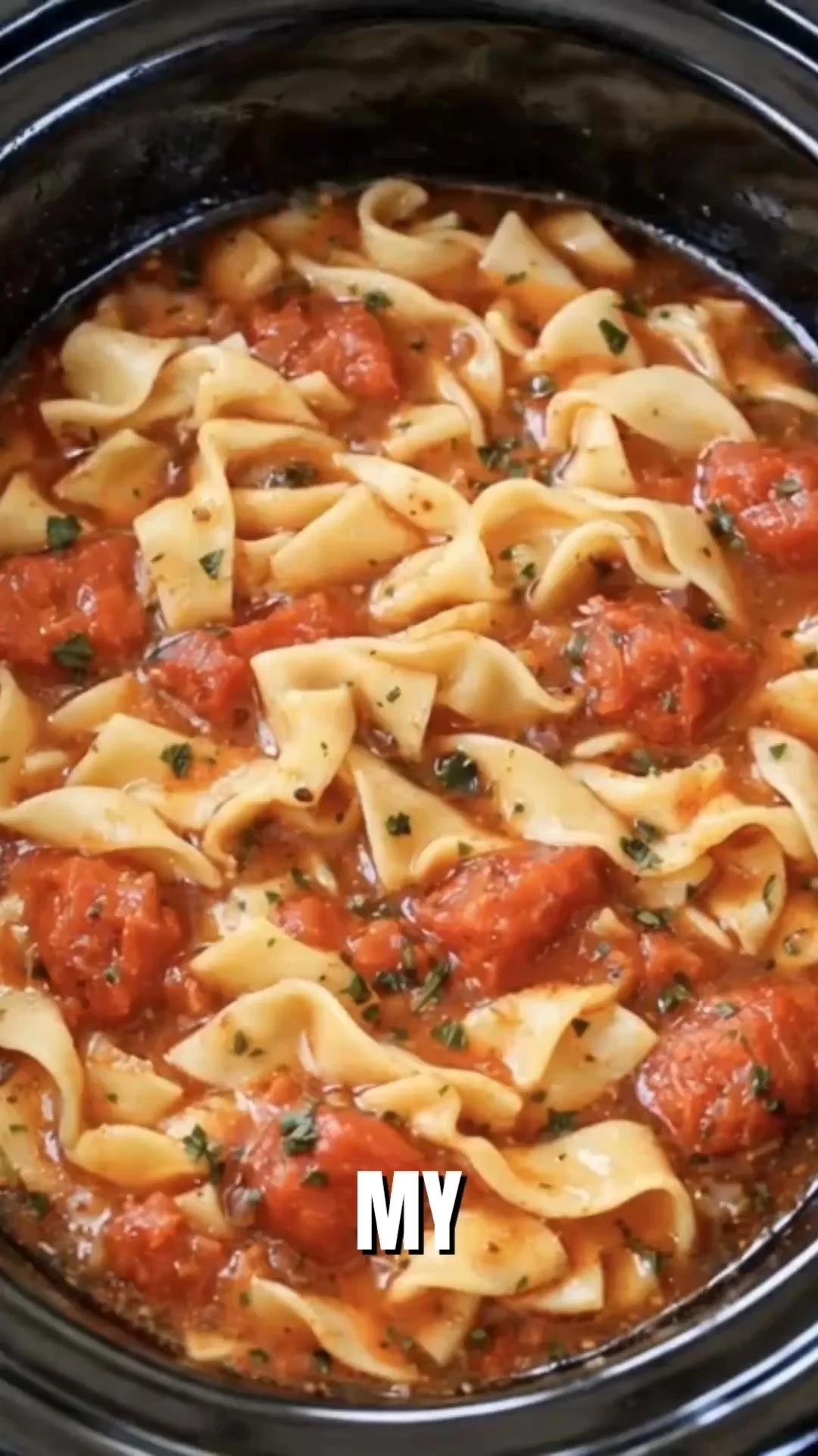 Bowl of Slow Cooker Amish Tomato Noodle Soup with noodles and fresh tomatoes.
